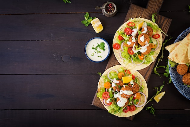 Tortilha com falafel e salada fresca. Tacos veganos. Comida vegetariana saudável. Vista do topo