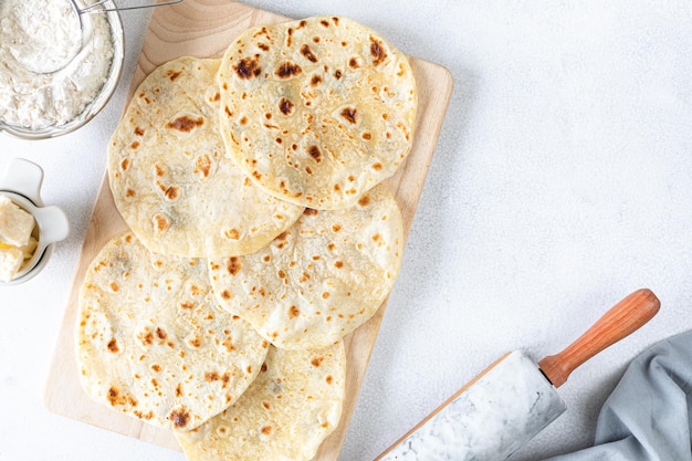 Tortilhas de trigo caseiras pita pão tortilla pita com ingredientes para cozinhar em uma mesa branca vista superior espaço de cópia