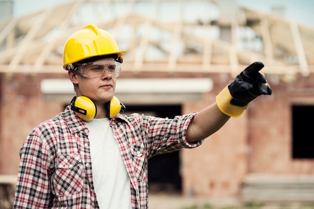 Trabalhador da construção civil apontando para algo