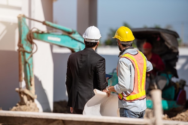 Trabalhador da construção civil e engenheiro trabalhando juntos no canteiro de obras