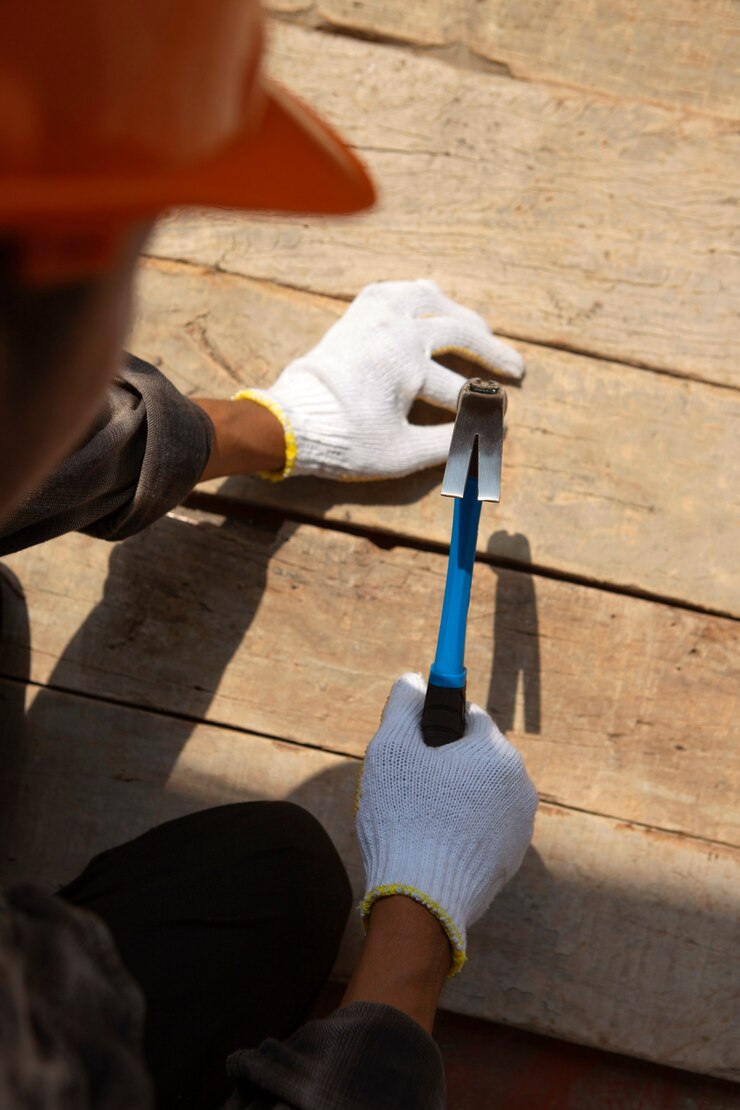 Foto grátis trabalhador da construção civil usando martelo no local de trabalho