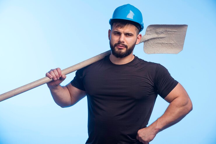 Foto grátis trabalhador da construção com capacete azul segurando o equipamento