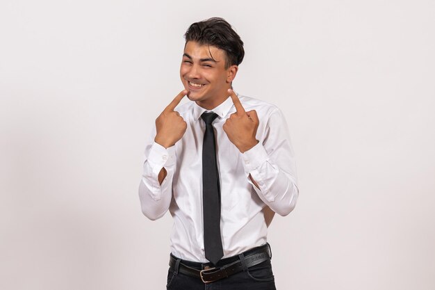 Trabalhador de escritório masculino de vista frontal mostrando os dentes na parede branca.