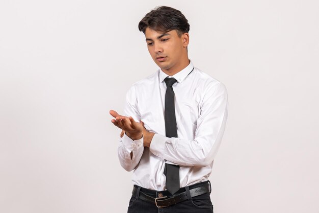 Trabalhador de escritório masculino de vista frontal, parado na parede branca, trabalho de escritório humano