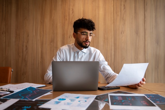 Foto grátis trabalhador de escritório usando gráficos de finanças