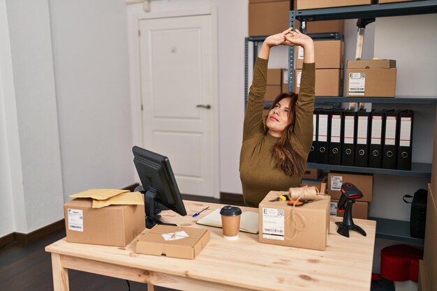 Trabalhador de negócios jovem latina esticando os braços no escritório