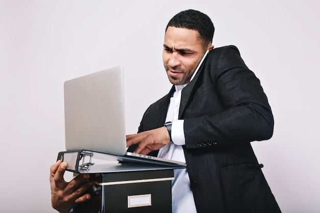 Trabalhador de oficce surpreso retrato segurando pastas, laptop falando no telefone. homem de negócios elegante, construindo carreira, gerente inteligente, trabalho moderno, mal-entendido.