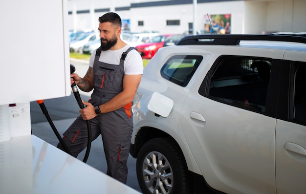 Foto grátis trabalhador de posto de gasolina cuidando do carro do cliente