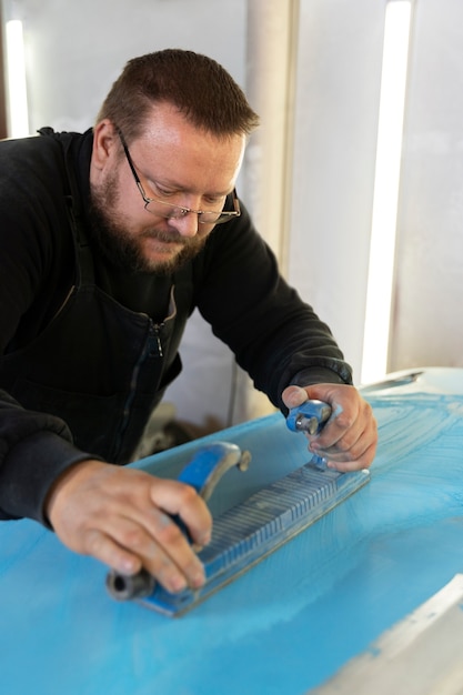 Trabalhador de serviço pintando carro em auto serviço