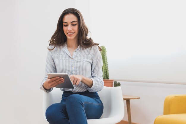 Trabalhador de sorriso novo que usa seu tablet