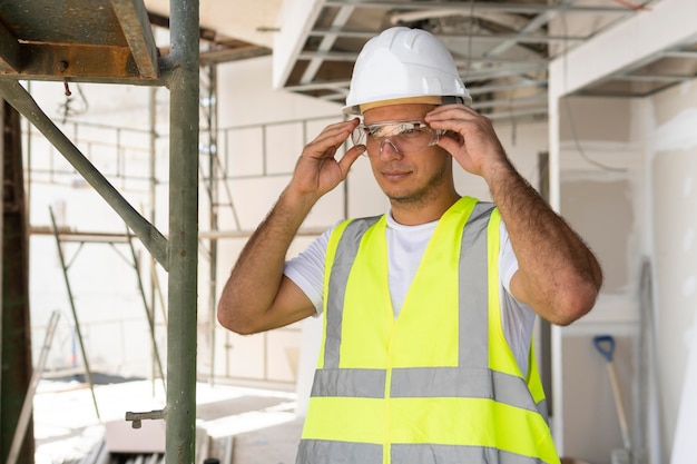 Trabalhador de visão frontal na construção usando equipamento de proteção