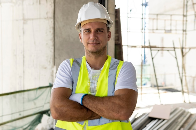 Foto grátis trabalhador de visão frontal na construção usando equipamento de proteção