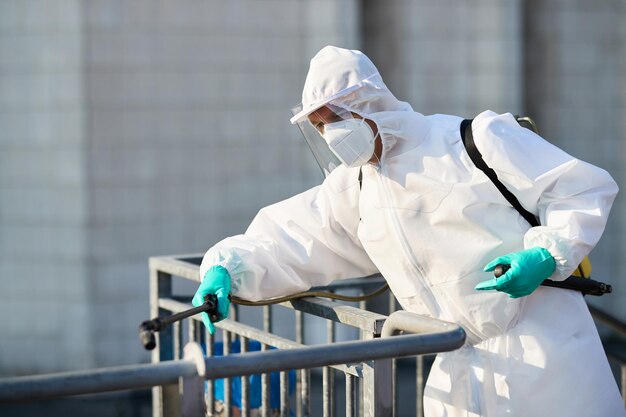 Trabalhador desinfetante higienizando a área da cidade para evitar a propagação do coronavírus