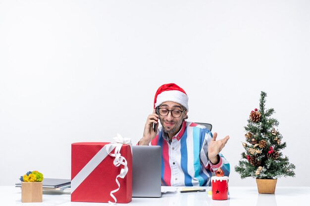 Trabalhador do sexo masculino com vista frontal sentado em seu lugar com um laptop falando