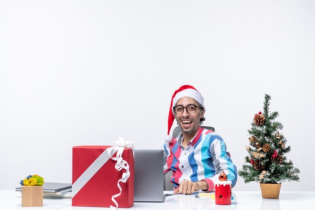 Trabalhador do sexo masculino de vista frontal sentado em seu lugar com um laptop segurando documentos, trabalho, emoções, escritório, natal