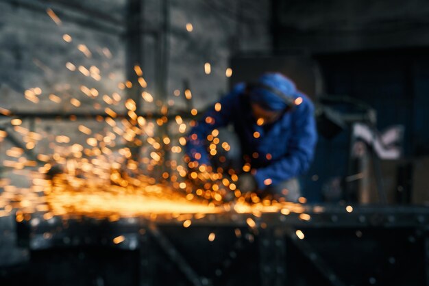 Trabalhador fazendo portão com máquina de corte de aço elétrico