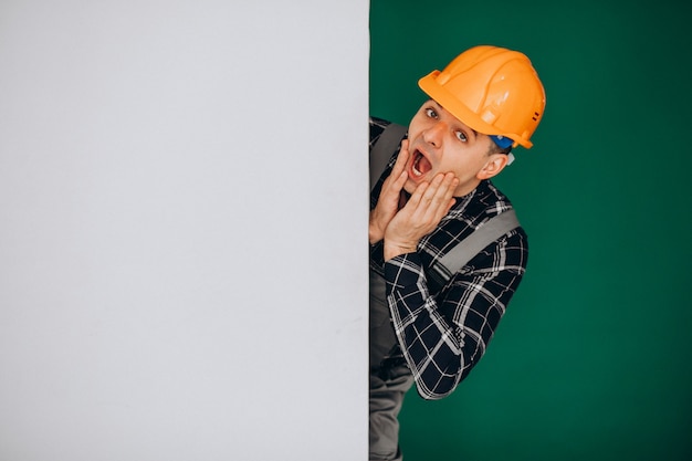 Foto grátis trabalhador homem no capacete isolado na parede verde