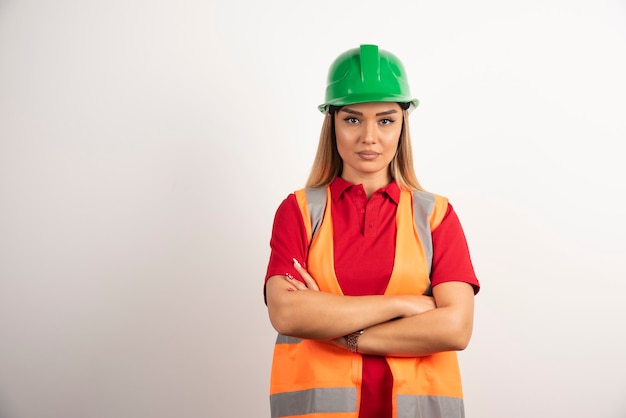 Trabalhador industrial feminino posando de uniforme e capacete.