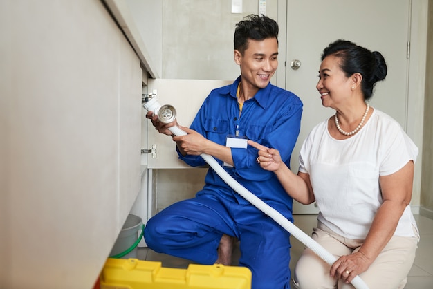 Foto grátis trabalhador manual que ajuda a mulher sênior na cozinha