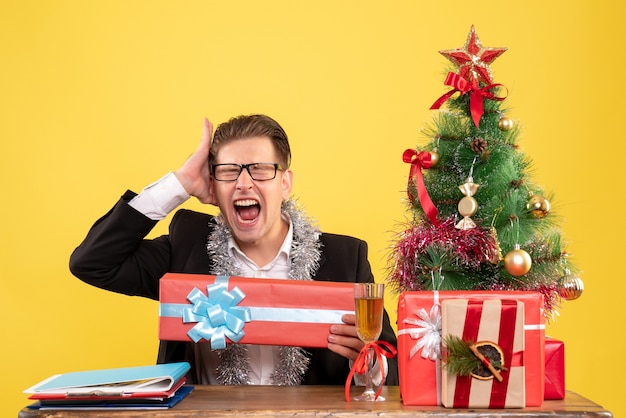 Trabalhador masculino sentado de frente e segurando um presente de natal