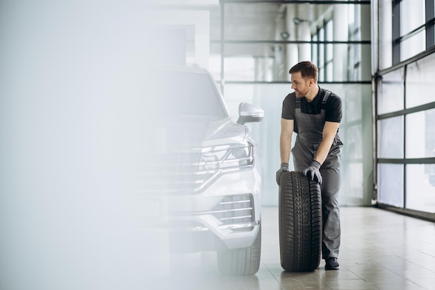 Foto grátis trabalhador na oficina de reparação de automóveis, trocando pneus