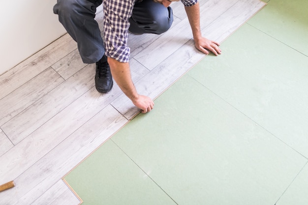 Foto grátis trabalhador processando um piso com placas de piso laminado brilhante