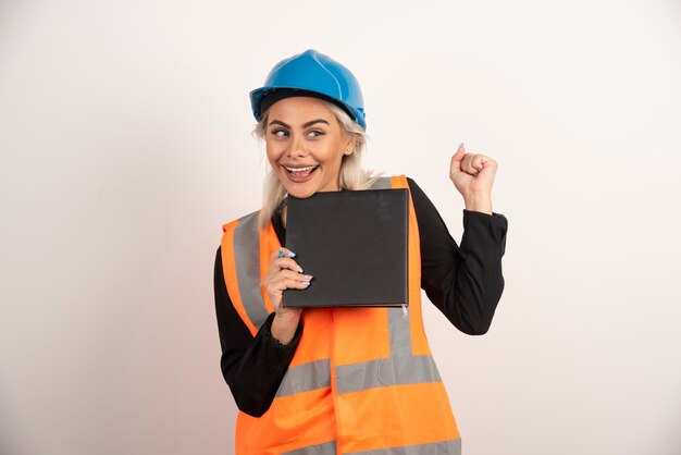 Trabalhador sorridente com notebook em pé sobre fundo branco. Foto de alta qualidade