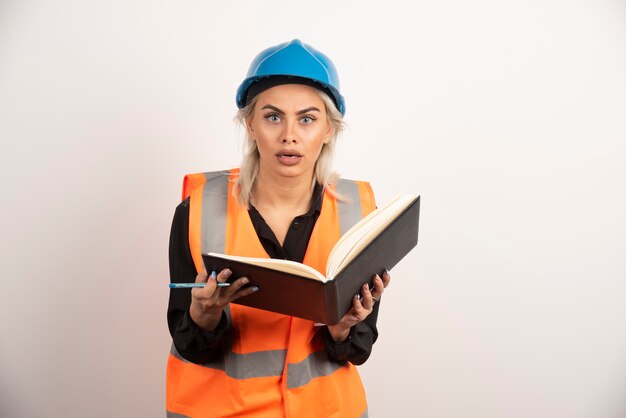 Trabalhador surpreso segurando o caderno em fundo branco. Foto de alta qualidade