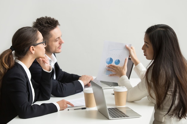 Trabalhadora, apresentando modelos visuais para colegas de trabalho