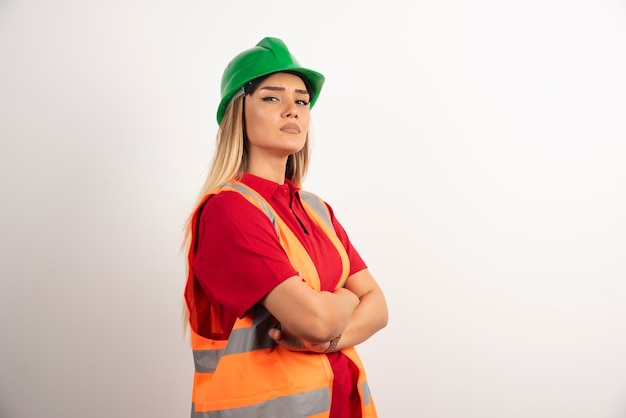Trabalhadora posando com capacete e uniforme.