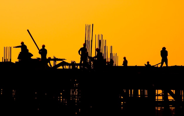 Trabalhadores da construção civil ao pôr do sol.