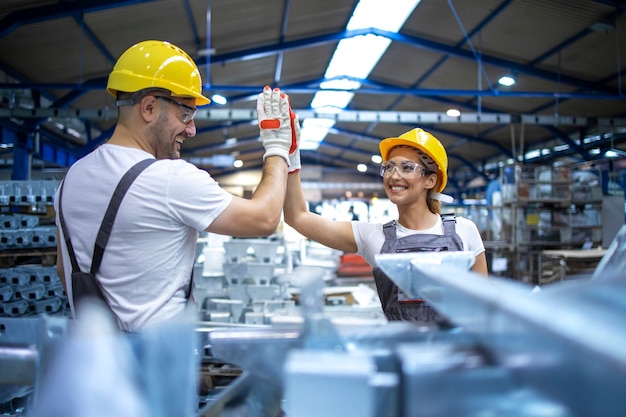 Trabalhadores da fábrica cumprimentando-se por um trabalho em equipe bem sucedido