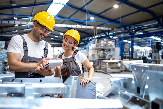 Trabalhadores da fábrica verificando a qualidade dos produtos em um grande salão industrial