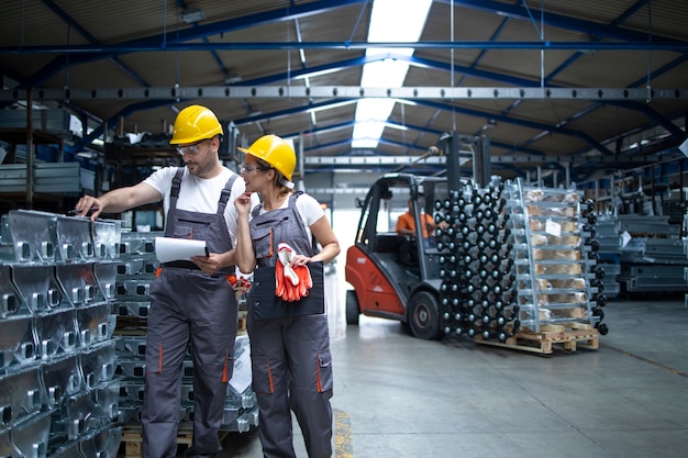 Trabalhadores da fábrica verificando a qualidade dos produtos no armazém industrial