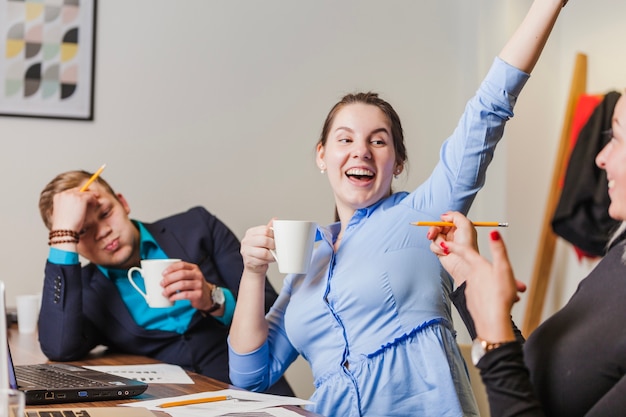 Trabalhadores de escritório sentados a mesa sorrindo