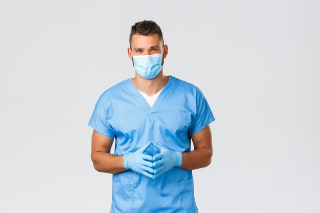 Trabalhadores de saúde, covid-19, coronavírus e prevenção do conceito de vírus. Médico simpático e simpático, enfermeira de uniforme e máscara médica, ouvir o paciente durante a triagem casual, plano de fundo cinza