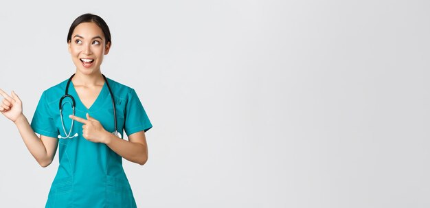 Trabalhadores de saúde Covid conceito pandêmico otimista sorridente enfermeira asiática em uniforme parece...