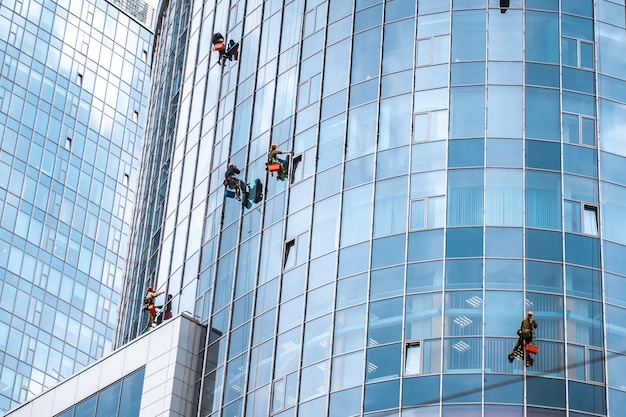 Foto grátis trabalhadores lavando janelas no prédio de escritórios