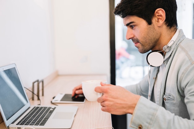 Foto grátis trabalhando no laptop masculino bebendo café