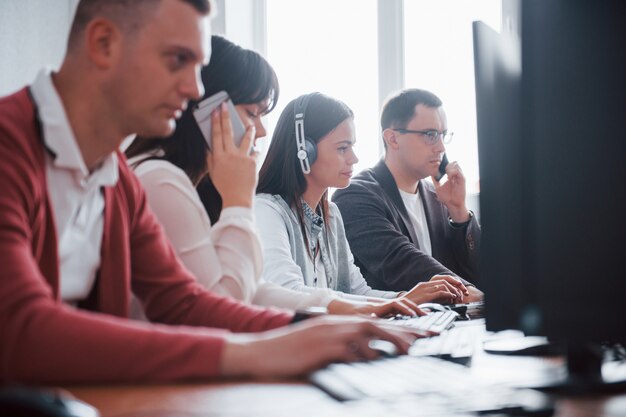 Trabalho de rotina diária. Jovens que trabalham no call center. Novos negócios estão chegando