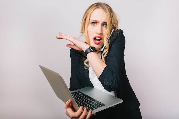 Foto grátis trabalho o tempo de escritório de ocupada jovem empresária em terno formal com laptop falando no telefone. humor chateado, surpreso, estar atrasado, reuniões, trabalho, profissão, secretária