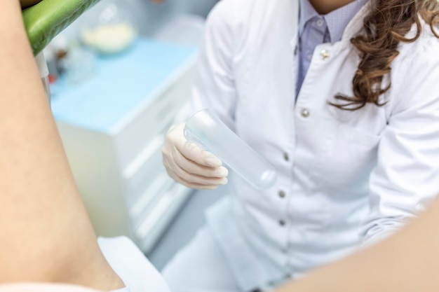 Tratamento da doença cervical Paciente feminina ginecologista na cadeira ginecológica durante o check-up com espéculo ginecológico