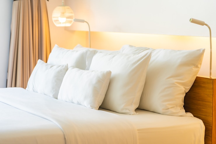 Foto grátis travesseiro branco e cobertor na decoração da cama no interior do quarto
