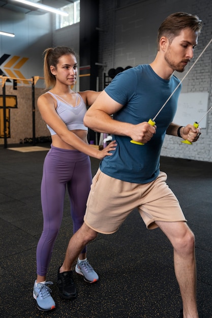 Foto grátis treinador, ajudando o iniciante na academia