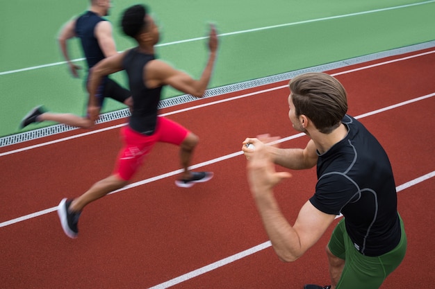 Foto grátis treinador bonito gritando perto de grupo jovem atleta multiétnico