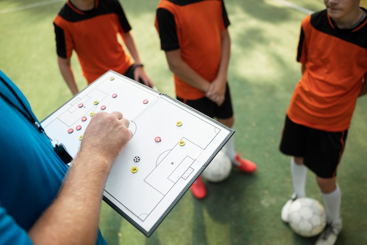Foto grátis treinador de futebol ensinando seus alunos