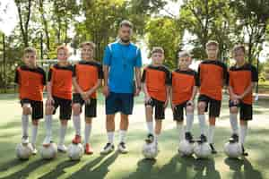 Foto grátis treinador de futebol ensinando seus alunos