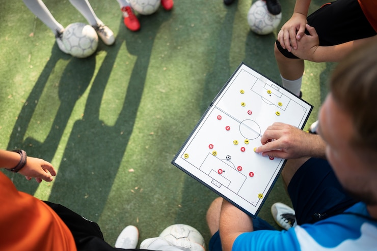 Foto grátis treinador de futebol ensinando seus alunos