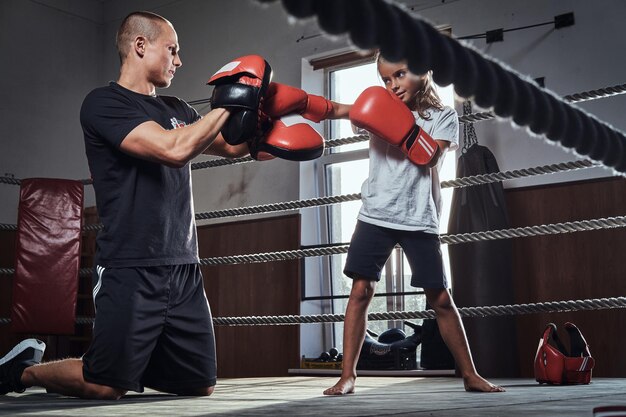 Treinador de jovem boxeador está treinando nova boxeadora para competições especiais.