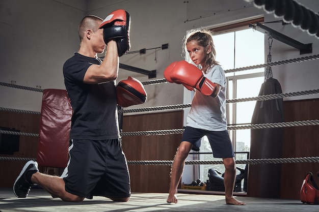 Foto grátis treinador de jovem boxeador está treinando nova boxeadora para competições especiais.